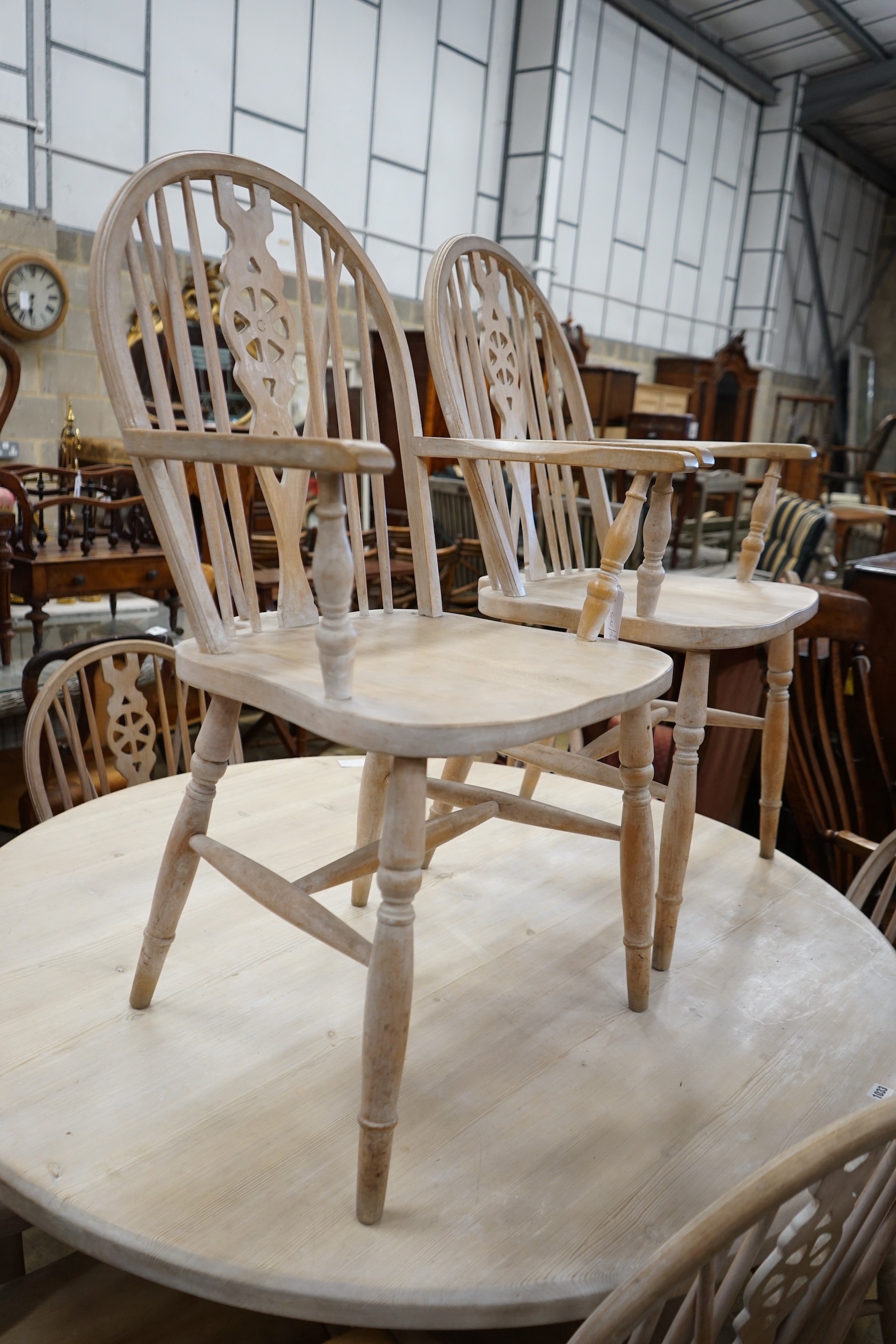 A set of eight Victorian style limed beech Windsor wheelback elbow chairs